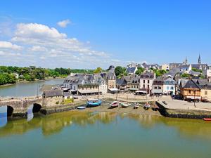 a town with a bridge and boats in the water at Chambre d'Hôtes à Bopérec in Nostang