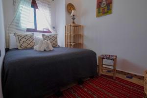 a bedroom with a bed with two stuffed animals on it at CASA ADiL in Tangier