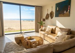 a living room with a couch and a view of the beach at Dolphin View Beach House in Walvis Bay