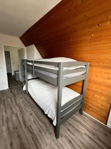 a bunk bed in a room with a wooden wall at Wunderschönes Haus am Waldrand für max 8 Personen in Harztor