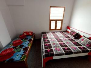 a bedroom with two beds and a window at Hotel Swami in Gogameri