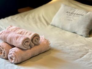 a pile of towels sitting on top of a bed at La Loge AL'AIX in Aix-les-Bains