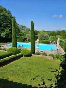 a view of a swimming pool with trees and umbrellas at La Ribaude in Crestet