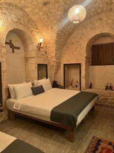 a bedroom with a large bed in a stone room at Diib House Hotel in Urfa