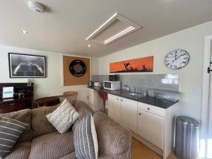 a living room with a couch and a clock on the wall at Wayside House B&B in Whichford