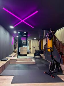 a gym with a purple ceiling with exercise equipment at Nómada Orzán bajo in A Coruña