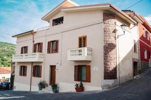 a white building with a balcony on a street at ARCU DE CHELU - GUEST HOUSE in Modolo