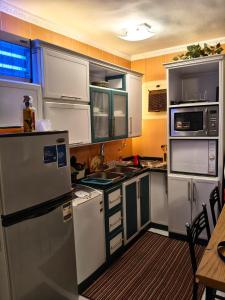 a kitchen with white appliances and a wooden table at Stella Di Mare Sea View - Amazing Two Bedrooms Standalone Cozy Villa - Families only in Ain Sokhna