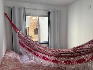 a hammock hanging from a window in a bedroom at Recanto da Frida in Caucaia