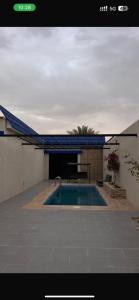 a swimming pool in front of a building at هدوء المنتهى in Al Munayzilah