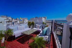 a balcony with a couch and a table and chairs at CASA ADiL in Tangier