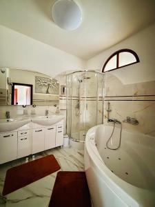a bathroom with two sinks and a tub and a shower at Apartmán Ela in Komárno +6 photos
