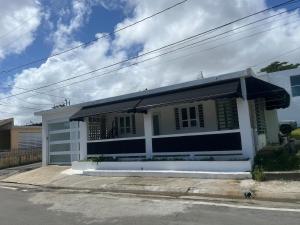 a small white house with an umbrella on a street at serenity in Fajardo