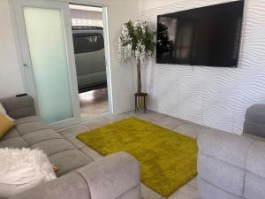 a living room with a couch and a flat screen tv at serenity in Fajardo