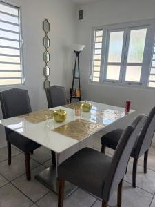 a dining room with a white table and chairs at serenity in Fajardo +8 photos