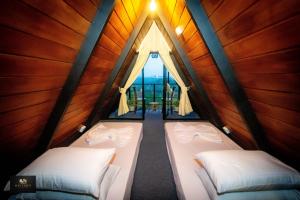 two beds in a room with a window at HAVENRO Weligama in Weligama