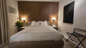 ein großes Bett in einem Hotelzimmer mit zwei Lampen in der Unterkunft Nahi Suite in Yanbu