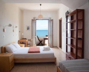 a bedroom with a bed and a view of the ocean at Three Brothers in Mandrákion