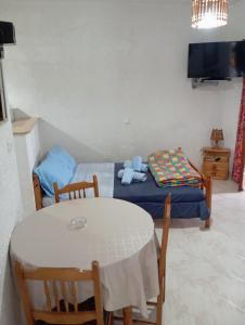 a room with a table and a bed and a tv at Akrata Golden Beach House 3 in Aíyira