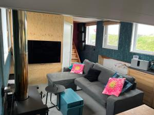 a living room with a couch and a flat screen tv at WoonBoten Anna in Andijk