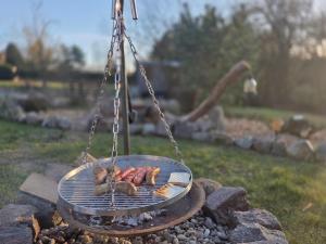 a grill with three sausages and other food on it at Camping - Wohnmobilstellplatz in der Seenplatte in Carpin