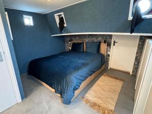 a bedroom with a bed in a blue room at WoonBoten Anna in Andijk