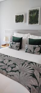 a large white bed with green pillows on it at Villa Regadio in Covilhã +57 photos