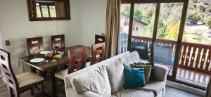 a living room with a couch and a table with a dining room at Apartamento Termas de Chillán in Nevados de Chillan