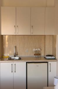 a kitchen with white cabinets and a sink at Antonios Apartments in Ulcinj