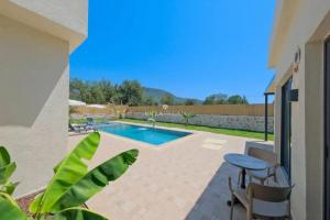 a patio with a pool and a table and chairs at villa tera Private Pool & jacuzzi in Fethiye