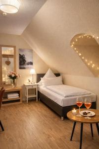 a bedroom with a bed and two tables with wine glasses at Zur Schlossbrücke in Ritterhude