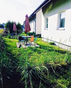 a table and chairs with umbrellas in the yard of a house at Mistral Jarosławiec in Jarosławiec