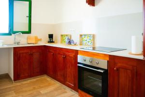a kitchen with wooden cabinets and a black and white oven at Muellito de Famara in Famara +34 photos