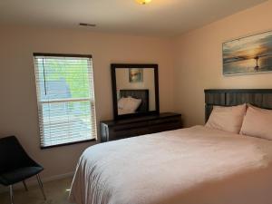 a bedroom with a bed and a mirror and a chair at Beautiful Bed and Bath in South Charlotte in Charlotte