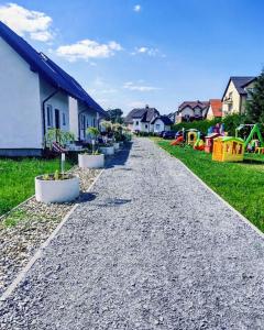 a gravel road with potted plants on the side of a house at Mistral Jarosławiec in Jarosławiec