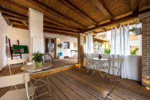 a living room with tables and chairs on a wooden floor at B&B Stentadì in Quartucciu
