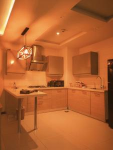 a kitchen with wooden cabinets and a table in it at Maison Veyra in Rawalpindi