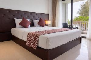 a bedroom with a large bed and a balcony at TBRS By Platinum Hotels in Trincomalee