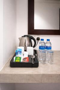 a kitchen counter with a tea pot and water bottles at TBRS By Platinum Hotels in Trincomalee
