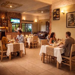 a group of people sitting at tables in a restaurant at Kivu Go-Lax Resort in Gisenyi