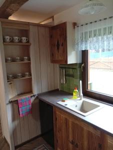 a kitchen with a sink and a window at Podlaska Chatka Dziadka in Ciwoniuki +15 photos