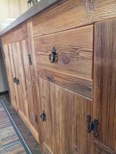 a large wooden cabinet with black knobs on it at Podlaska Chatka Dziadka in Ciwoniuki