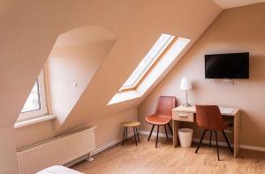 a room with a desk and two chairs and a tv at Zur Schlossbrücke in Ritterhude