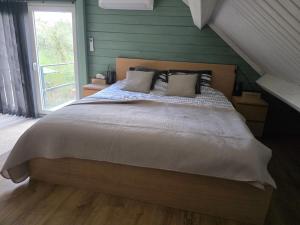 a bedroom with a large bed with green walls at StayTommy in Bertem
