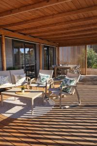 a patio with lounge chairs and tables on a deck at Panorama Mobilehome Vista Kornati with Pool in Drage