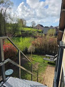 a view of a garden from the balcony of a house at StayTommy in Bertem
