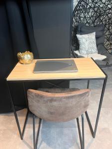 a desk with a laptop on top of a chair at Suite l Instant suspendu maison 25m2 avec coin salon Wifi Netflix Maison Like and Love Duclair in Duclair