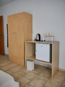 a room with a table and a wooden cabinet at Seaside Stay Makrygialos in Makrygialos