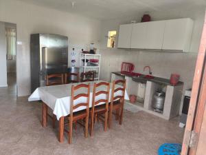 a kitchen with a table and chairs and a refrigerator at Paraíso do Abais, house for rent in Estância