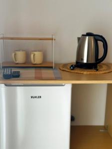 a tea kettle sitting on top of a refrigerator at Seaside Stay Makrygialos in Makrygialos